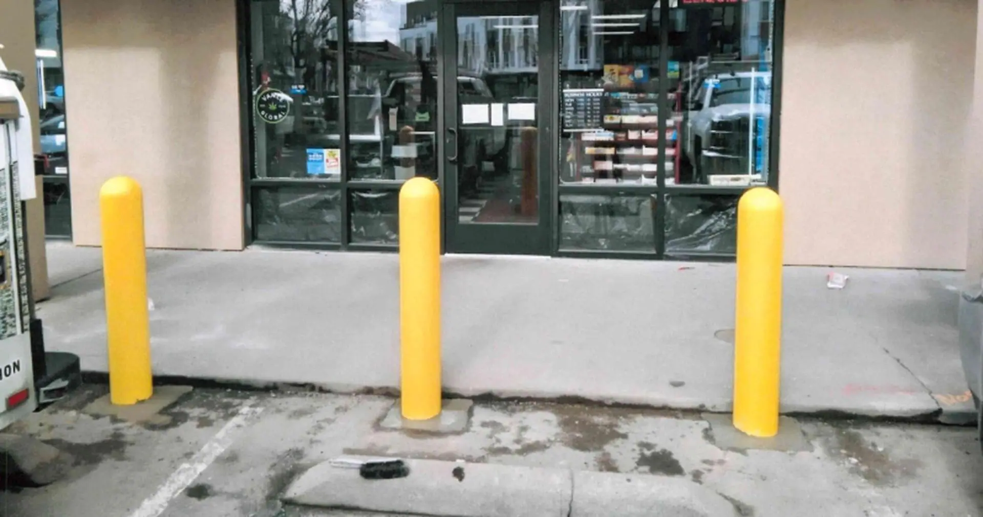 Yellow security bollards in front of a storefront